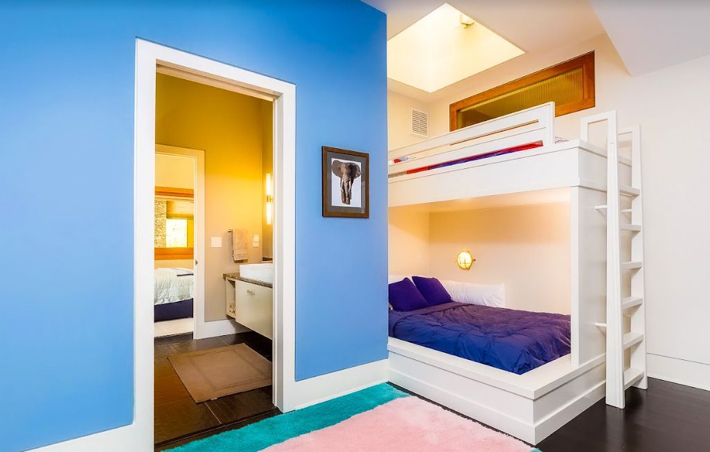 A bedroom with blue walls and a bunk bed.