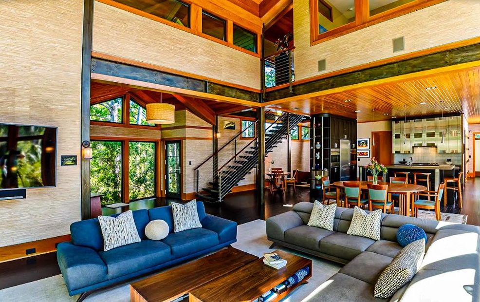 A living room filled with furniture and a staircase in a house.