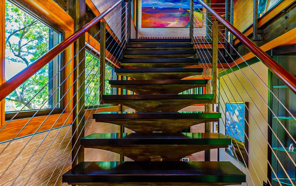A staircase in a house with a painting on the wall.