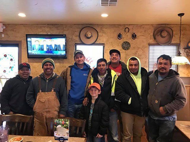 A group of men are posing for a picture in a restaurant. A group of men are posing for a picture in a restaurant.