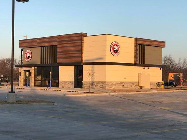A fast food restaurant with a parking lot in front of it.