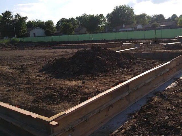 A pile of dirt sits in the middle of a construction site A pile of dirt sits in the middle of a construction site