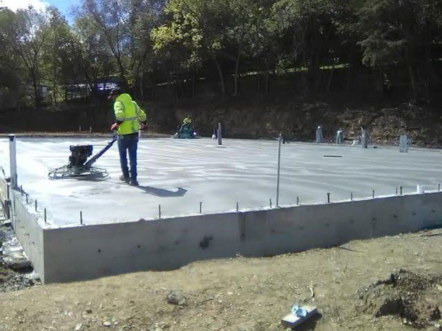 A man is working on a concrete floor with a machine. A man is working on a concrete floor with a machine.