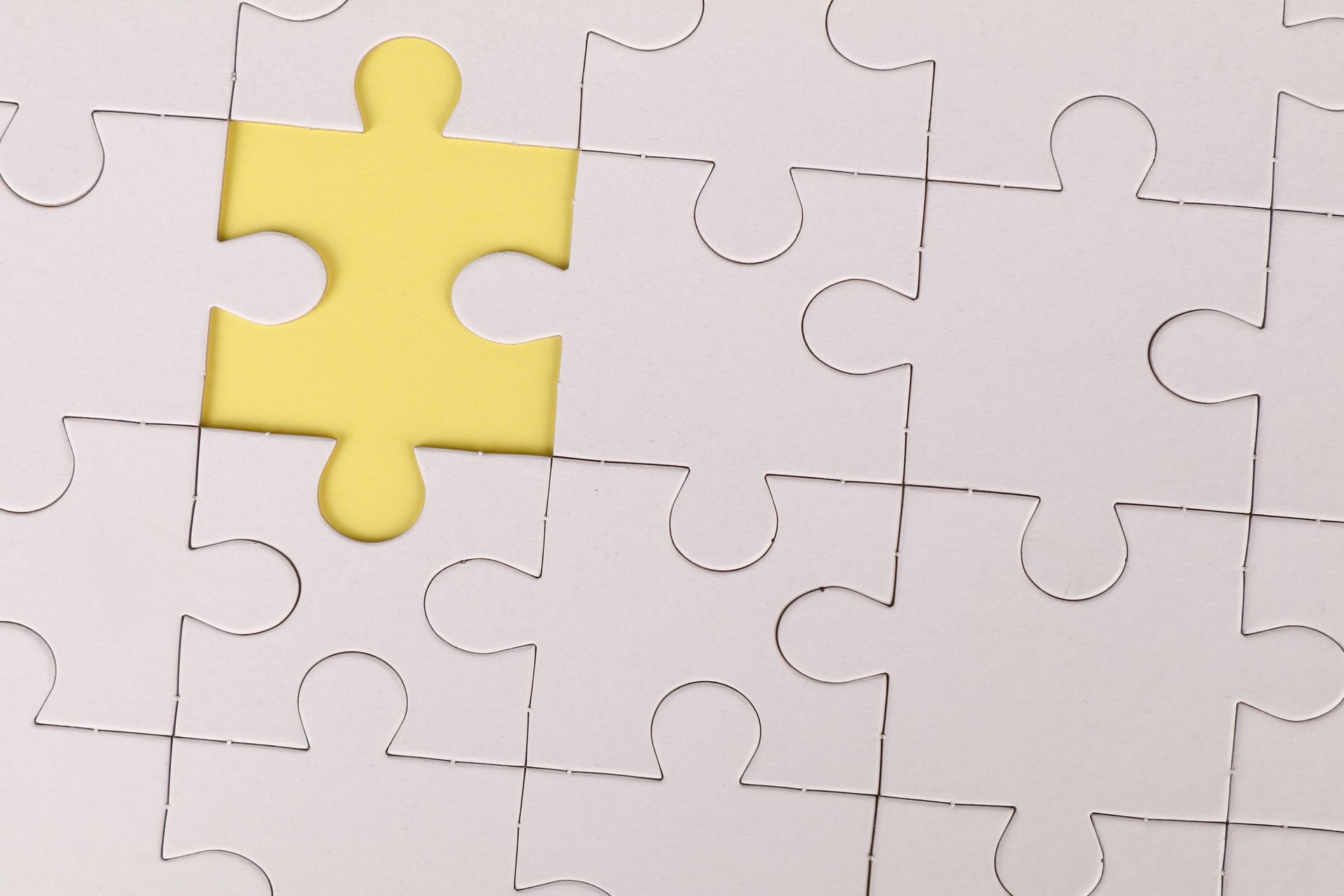 A white puzzle with a yellow piece in the middle