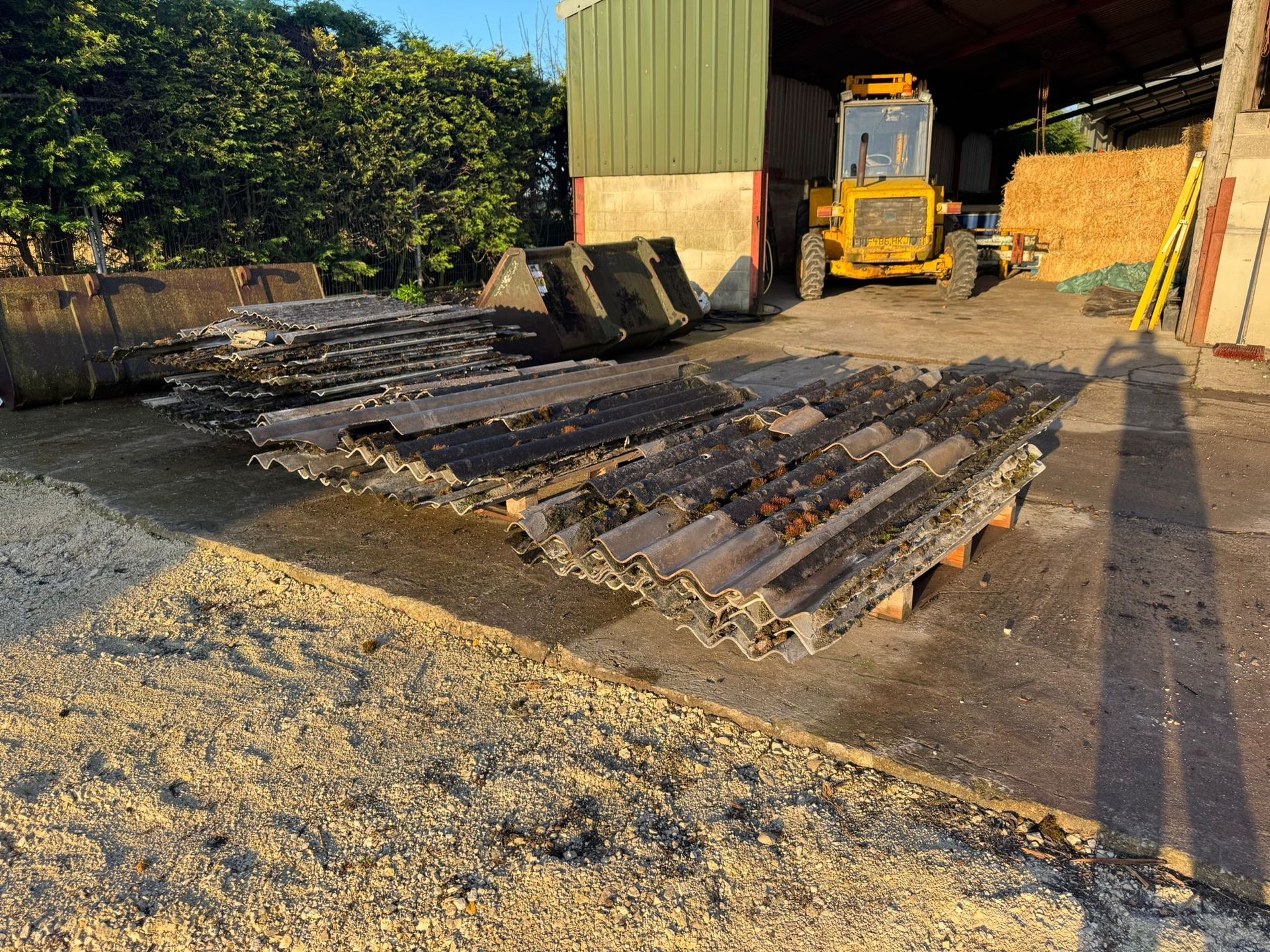 man in red boiler suit removing old roofing sheets
