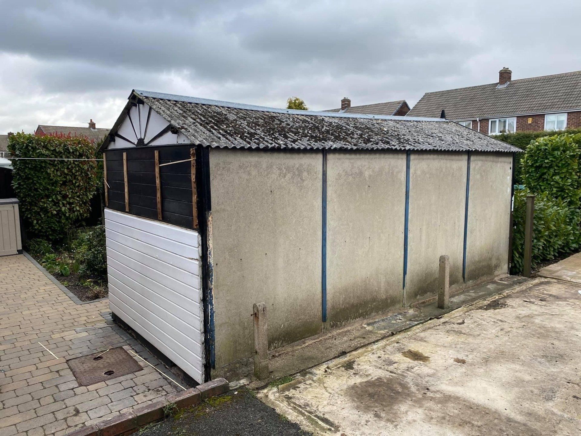 Red brick garage with grey asbestos roof
