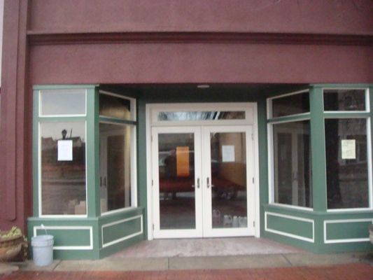 The entrance to a building with green trim and white doors