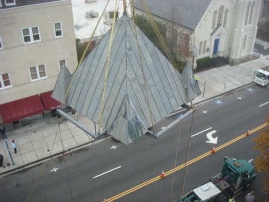 An aerial view of a building being lifted by a crane