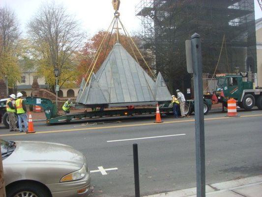 A large metal object is being lifted by a crane