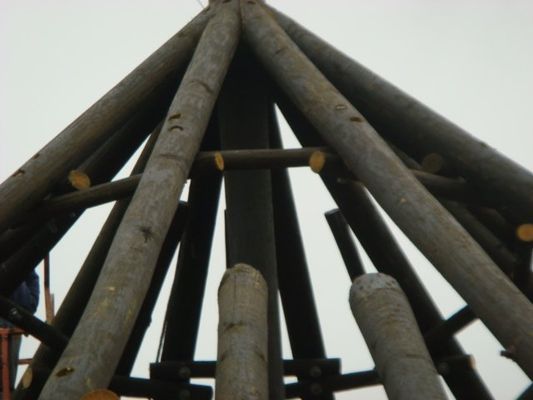 A bunch of wooden poles are stacked on top of each other