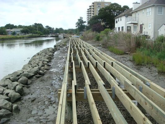 A row of wooden boards are lined up next to a body of water