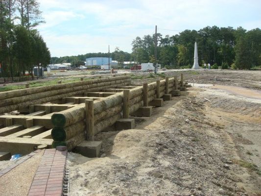 A wooden fence is being built in a dirt field.