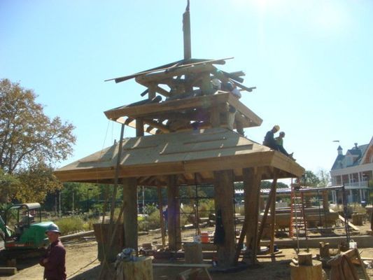 A group of people are working on a wooden structure