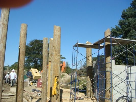 A construction site with scaffolding and wooden poles