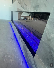 Modern fireplace with blue LED lighting set into a marble wall and floor niche