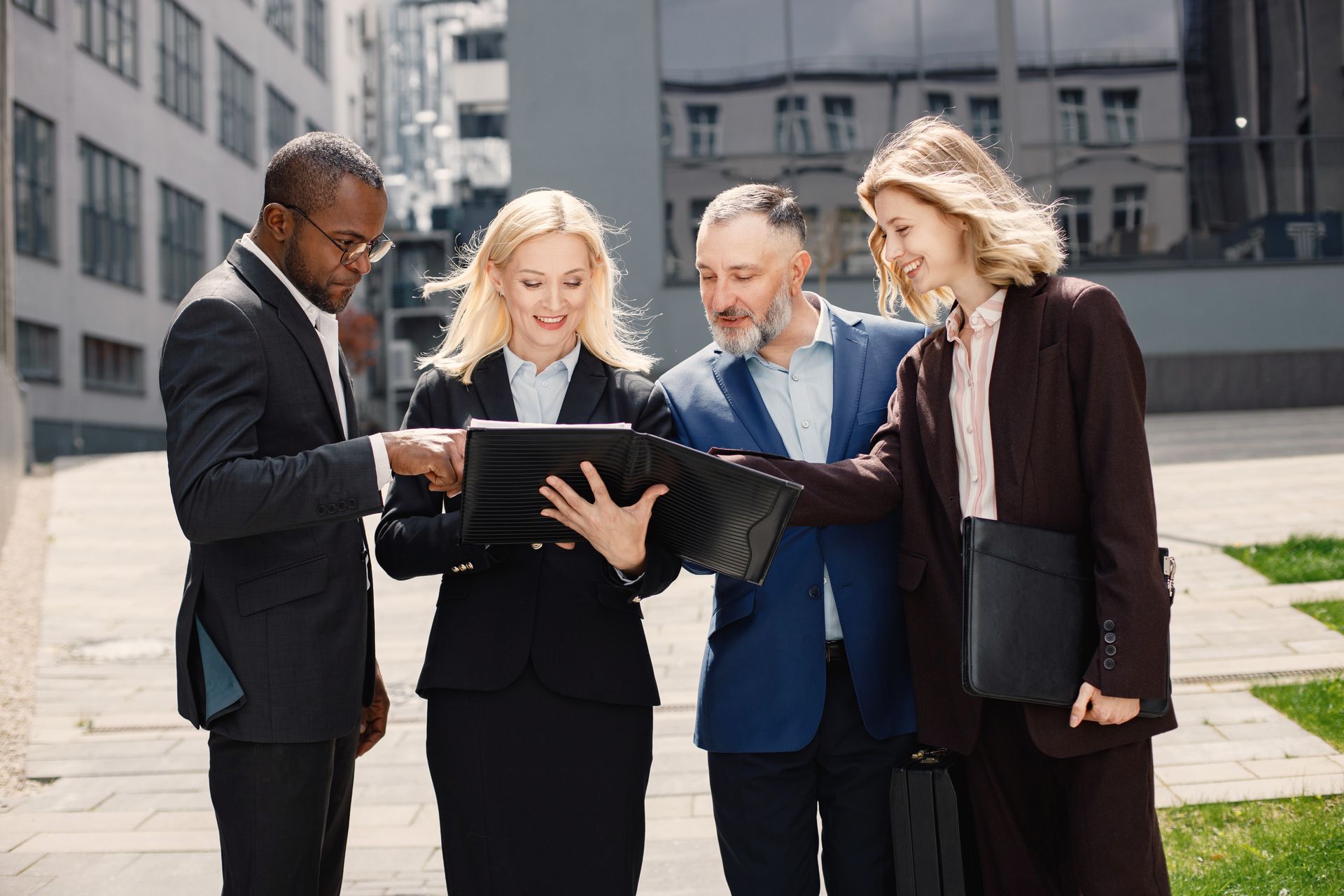 A group of business people are looking at a tablet.