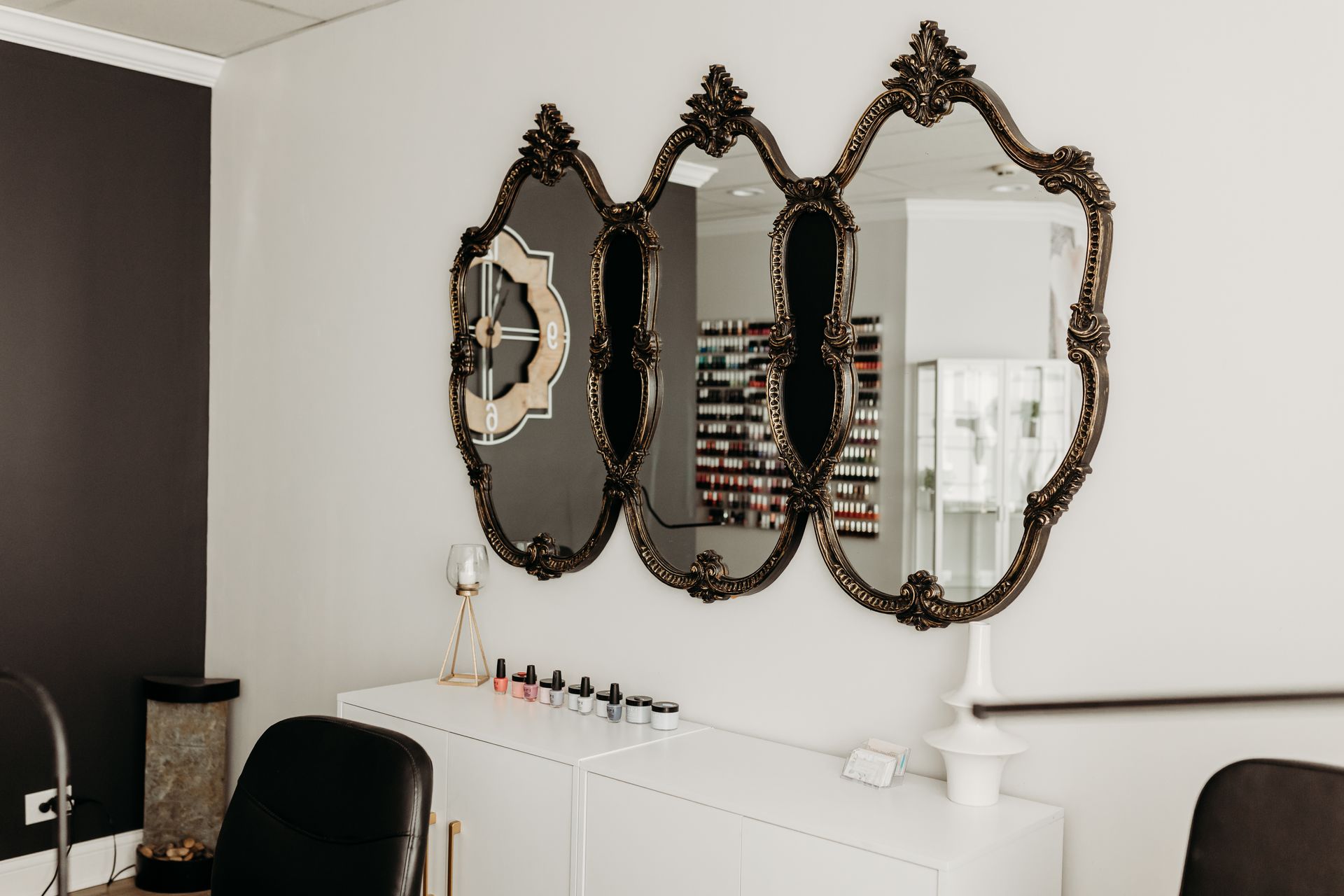 A room with three mirrors on the wall and a table.