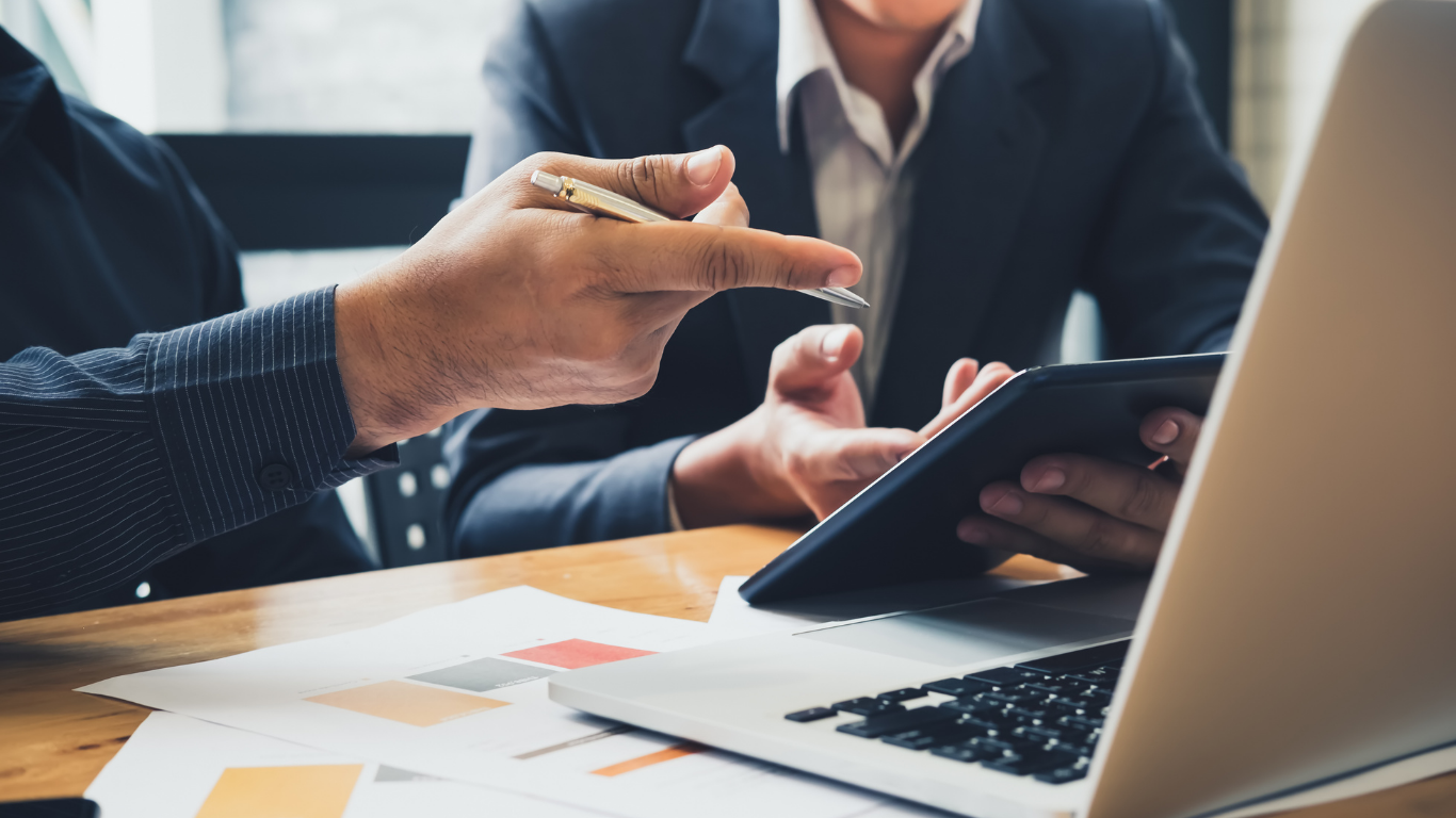 Hands pointing at charts and notes during a business meeting over papers on a table