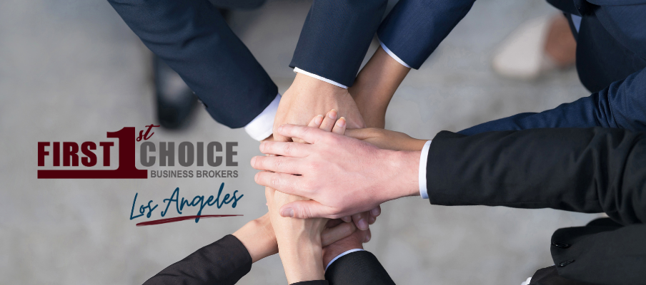 A group of people putting their hands together with the first choice logo in the background