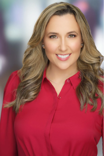 A woman in a red shirt is smiling for the camera.