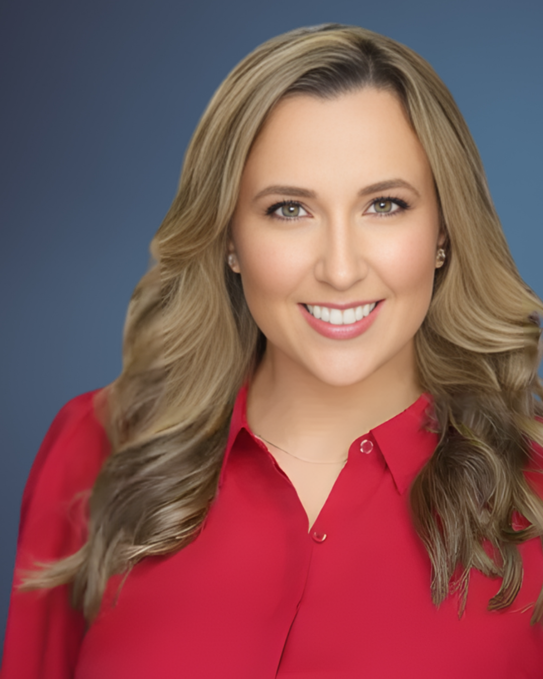 A woman in a red shirt is smiling for the camera.