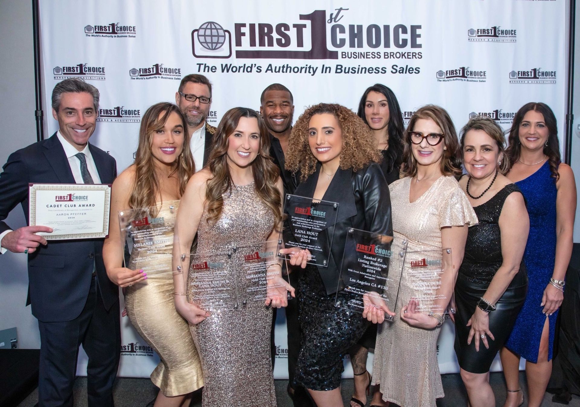 A group of people standing in front of a first choice banner
