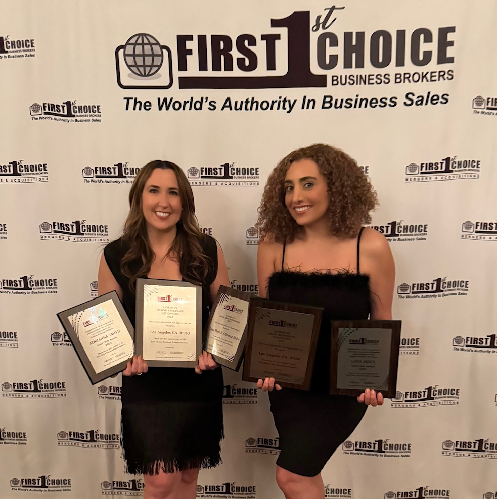 Two women are standing in front of a wall that says first choice business brokers