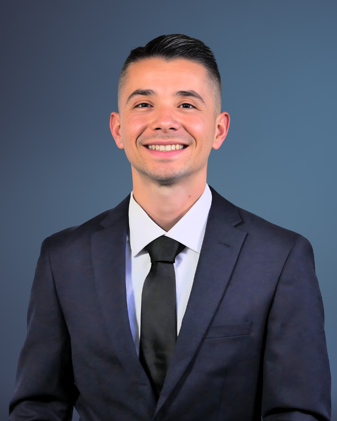 A man with a beard wearing a suit and tie is smiling for the camera.
