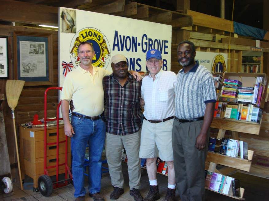 Four men pose in front of an