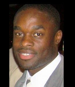 A man in a suit and tie is smiling for the camera.