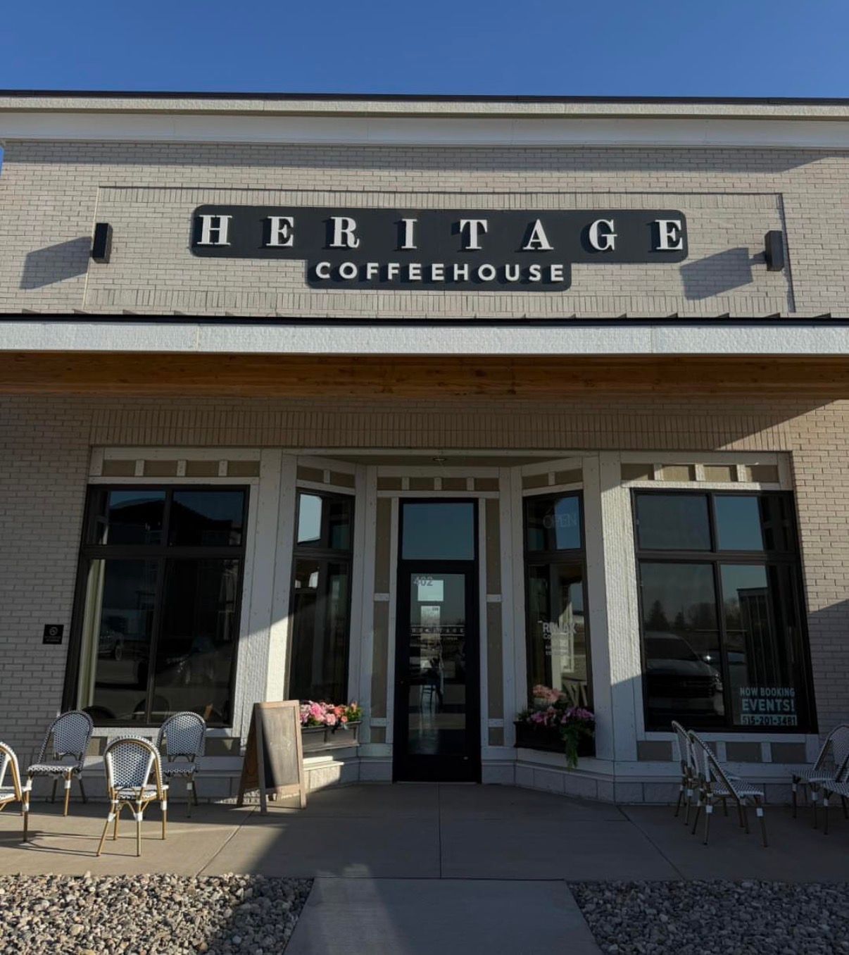 Exterior of Heritage Coffeehouse storefront with outdoor seating on a sunny day