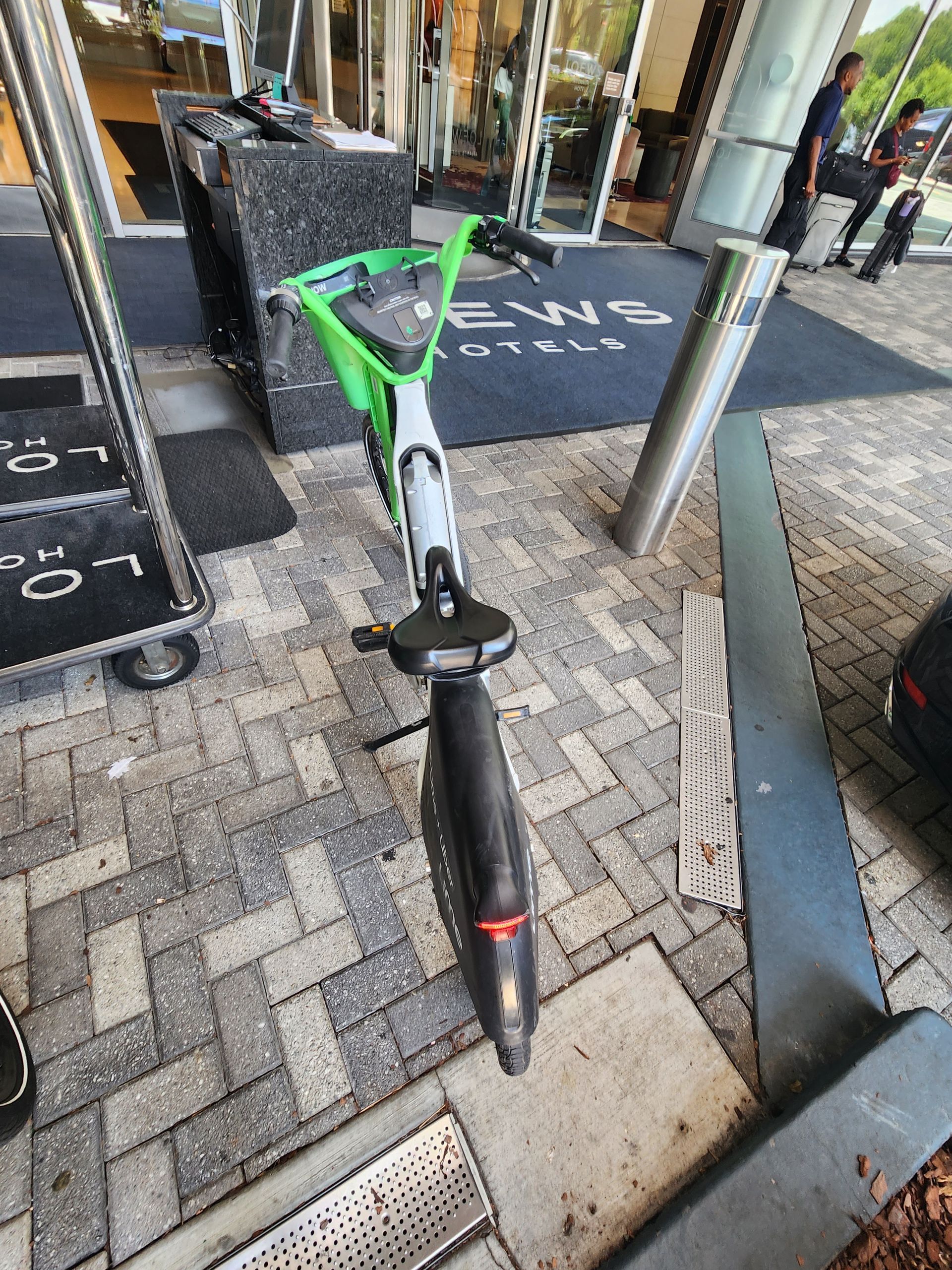 Lime scooter parked outside a building with a hotel name.