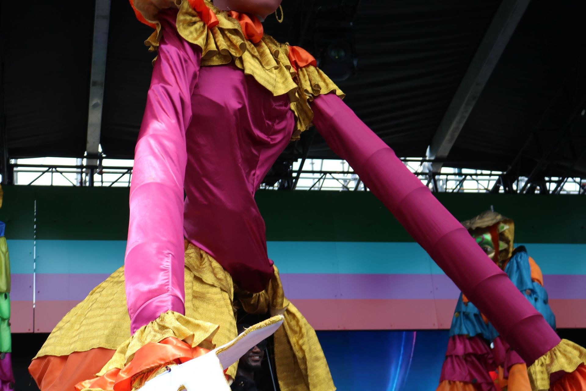 Colorful giant puppet legs at an indoor festival stage