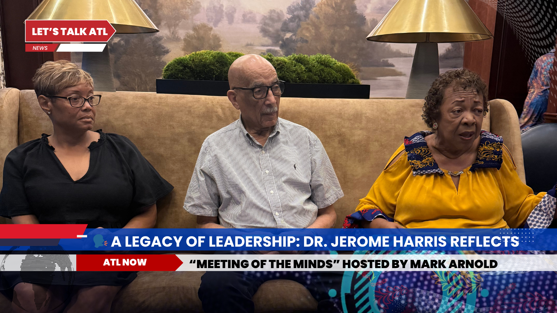 Three people on a couch during a TV interview. Text at the bottom: