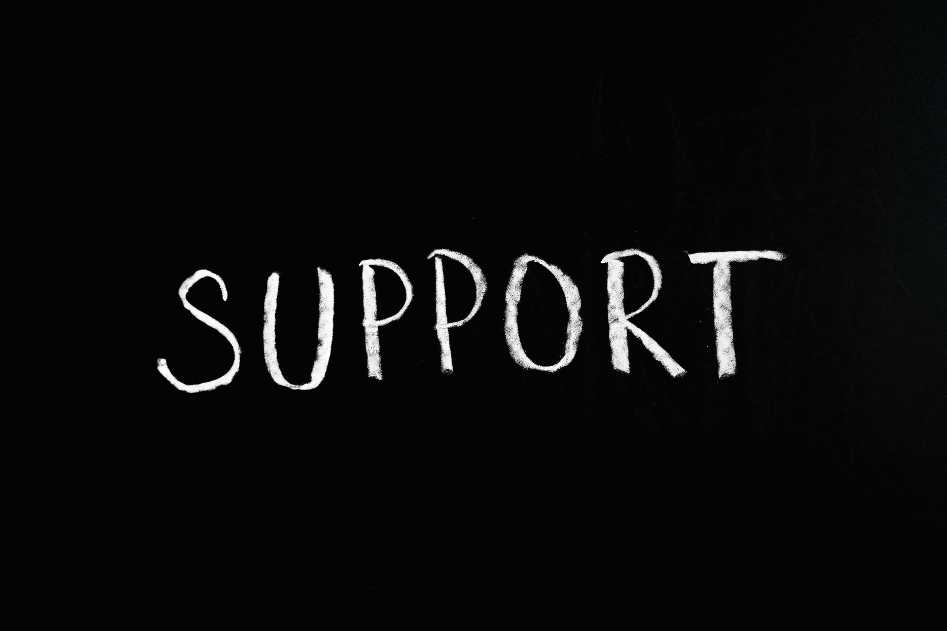 White chalk "SUPPORT" on a black background.