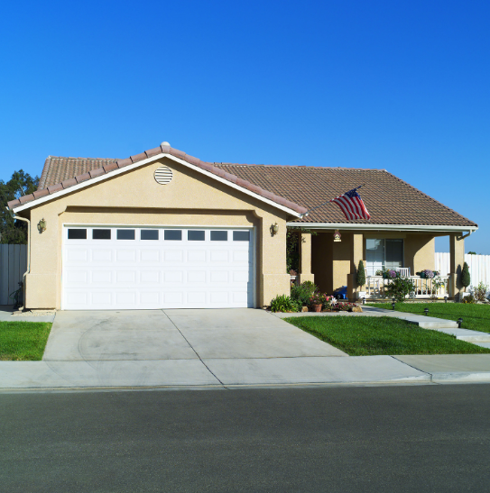 A house with a white garage door and an american flag