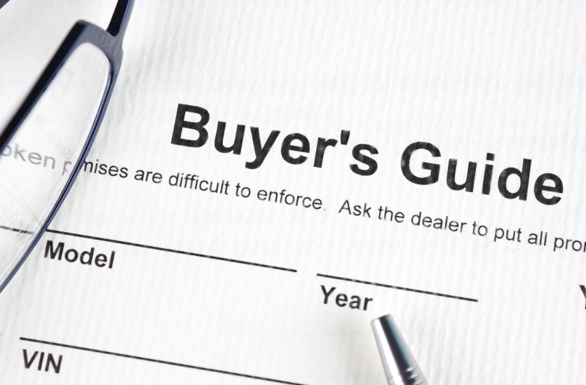A close up of a buyer 's guide with glasses and a pen