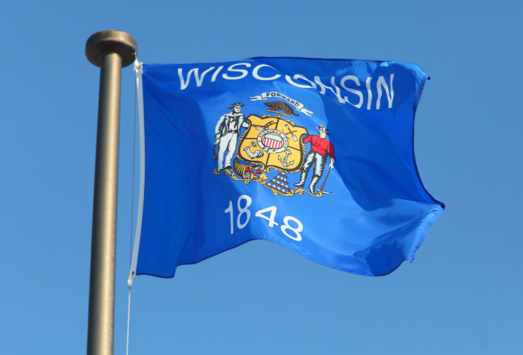 A wisconsin flag is flying in the wind