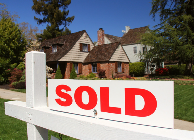 A house with a sold sign in front of it