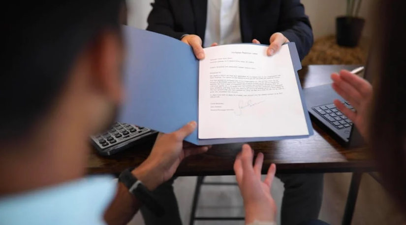 A man is holding a piece of paper in front of a group of people.