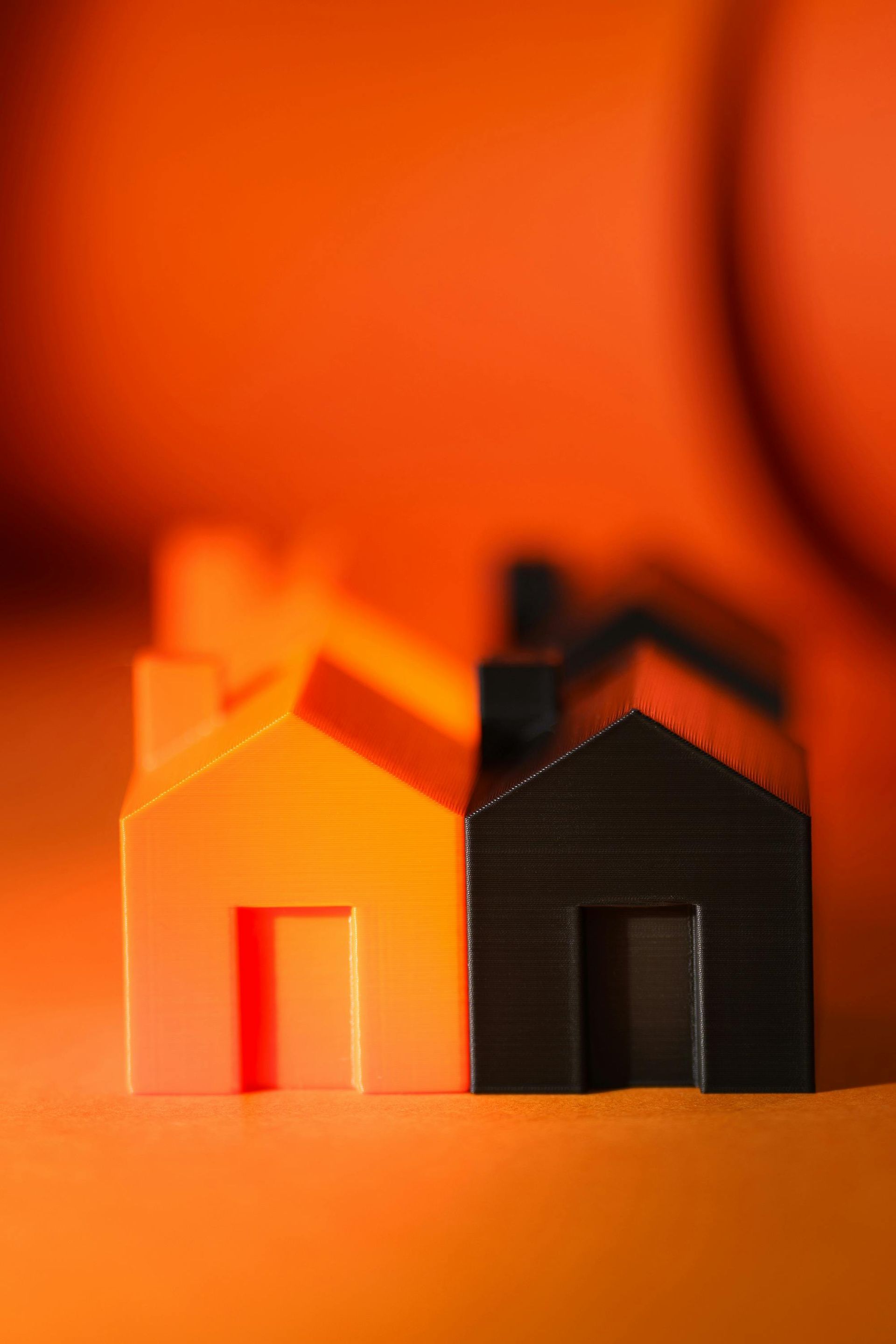 Two toy houses are sitting next to each other on a table.