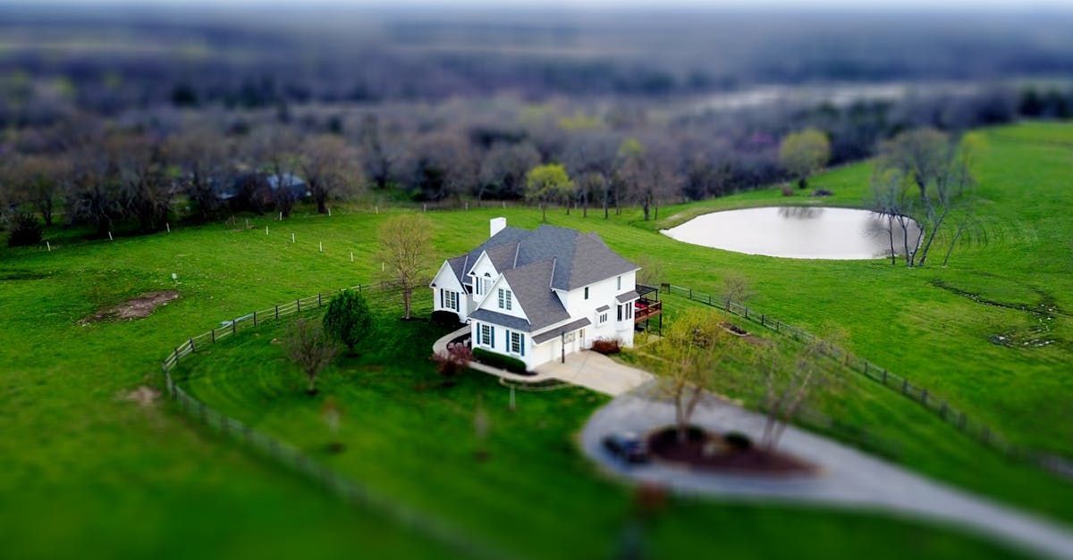 An aerial view of a house in the middle of a lush green field.