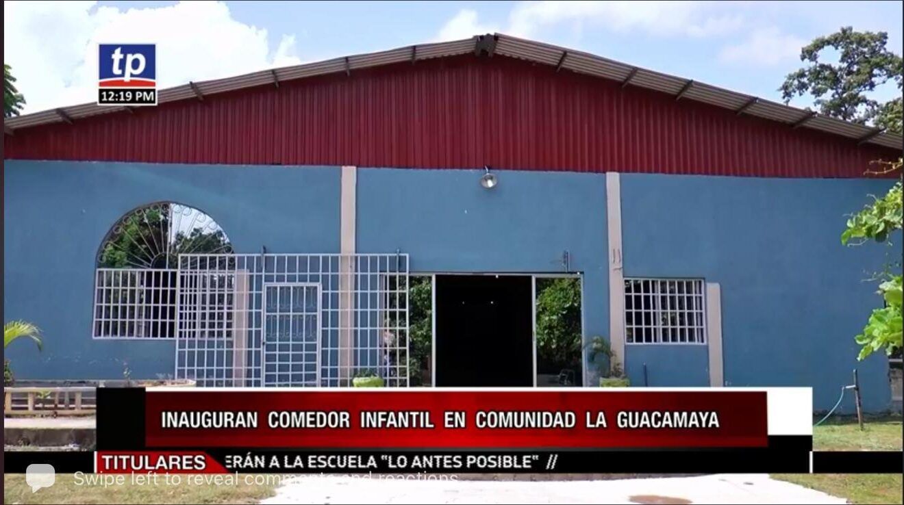 Blue school building with red roof and a sign reading “Paul Bhan Communication” in front