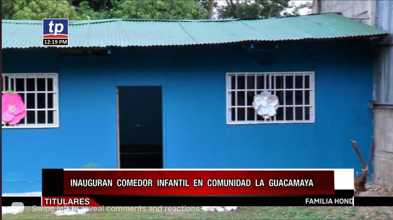 Blue community building with green roof, barred windows, and a central door; news-style Spanish caption at bottom
