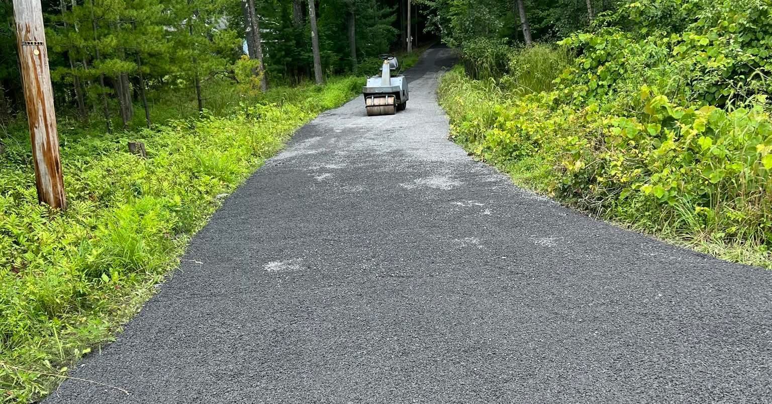 Small utility cart on a gravel path through a green forest.