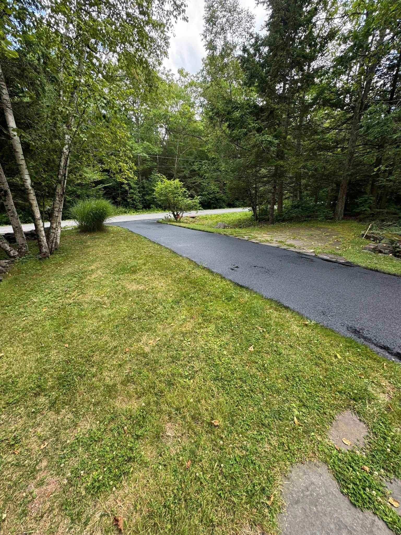 Gravel path curving through a green wooded park with grass and trees