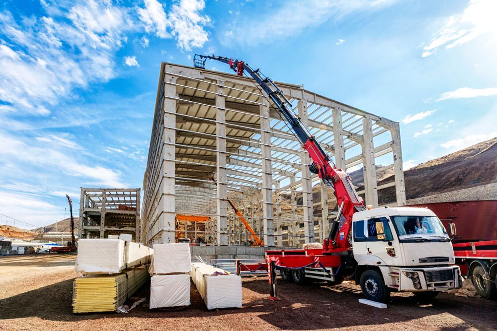 Construction Site With Crane Lifting Materials — Cairns Electrical Rewinds & Repairs In Bungalow, QLD