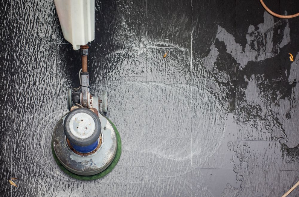 Floor Cleaner Scrubbing a Dark, Wet Floor — Cairns Electrical Rewinds & Repairs In Bungalow, QLD