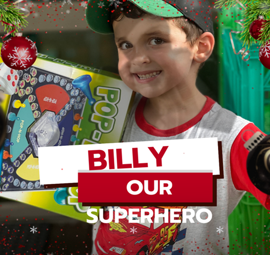 A young boy holding a box that says pop billy our superhero