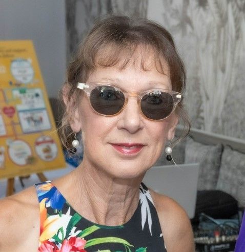 A woman wearing sunglasses and a floral dress